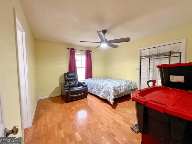 bedroom featuring hardwood / wood-style floors, a textured ceiling, and ceiling fan