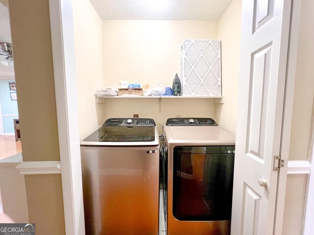 laundry room featuring washer and dryer and a textured ceiling