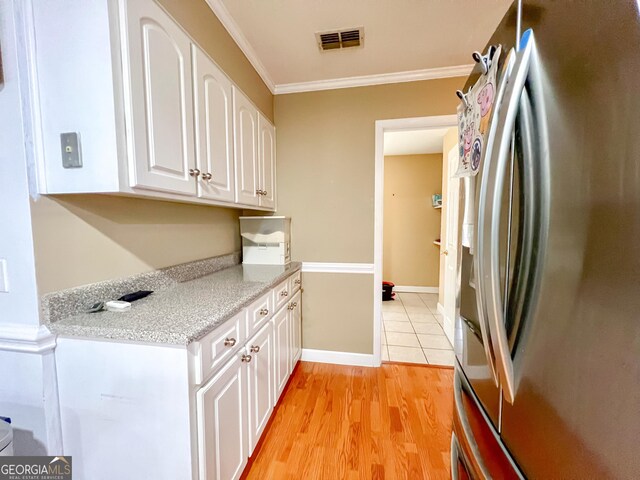 kitchen featuring stainless steel refrigerator with ice dispenser, white cabinetry, crown molding, and light hardwood / wood-style flooring