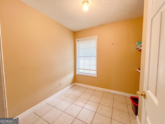 tiled spare room with a textured ceiling