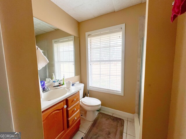 bathroom with walk in shower, vanity, toilet, and tile patterned flooring