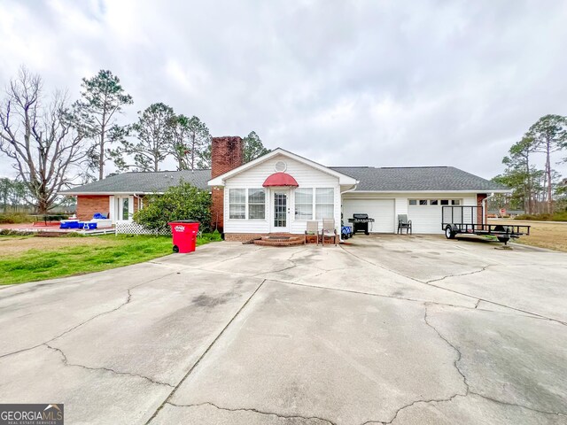 ranch-style home with a garage and a front lawn