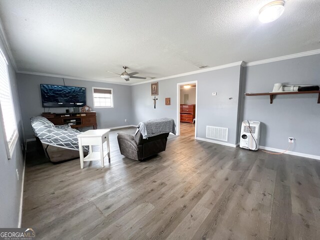 bedroom featuring crown molding, ceiling fan, hardwood / wood-style flooring, and a textured ceiling