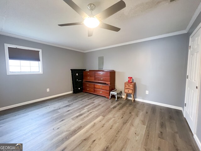 unfurnished bedroom featuring hardwood / wood-style flooring, crown molding, and ceiling fan