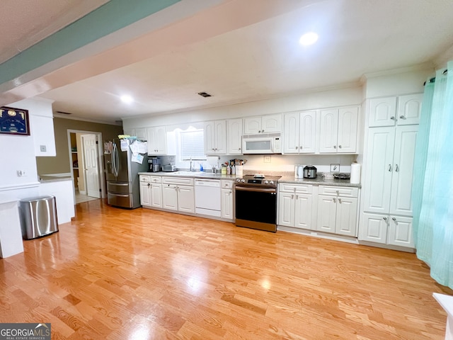 kitchen with white cabinetry, sink, ornamental molding, stainless steel appliances, and light wood-type flooring