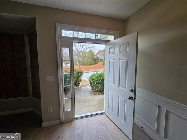 doorway featuring a textured ceiling and light wood-type flooring