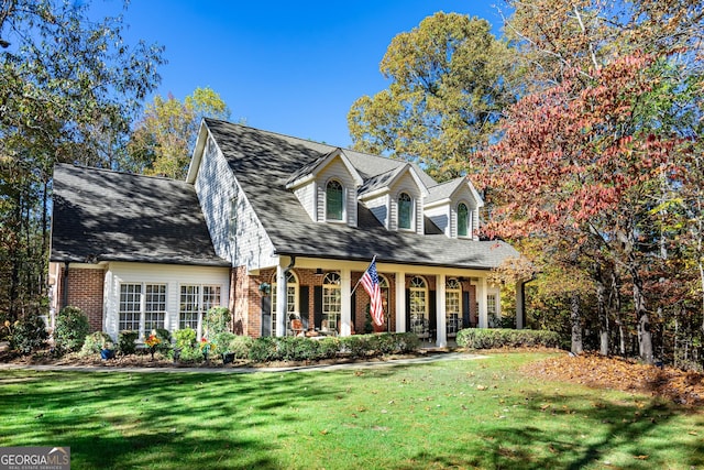 cape cod-style house featuring a front yard and a porch