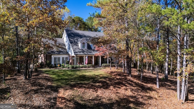 cape cod-style house featuring a front lawn and a porch