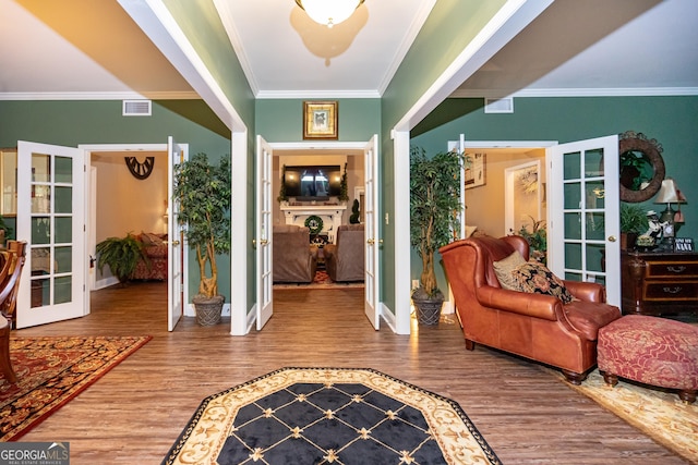 foyer featuring hardwood / wood-style flooring, crown molding, and french doors