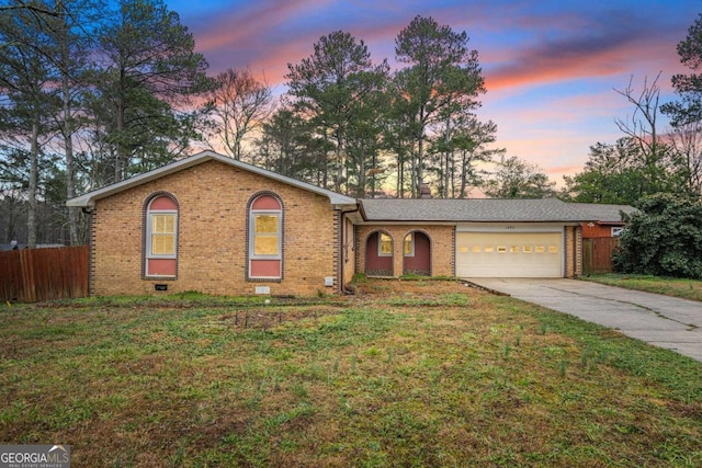 ranch-style house with a yard and a garage