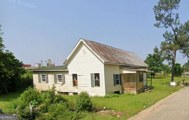 view of side of property featuring a porch and a yard