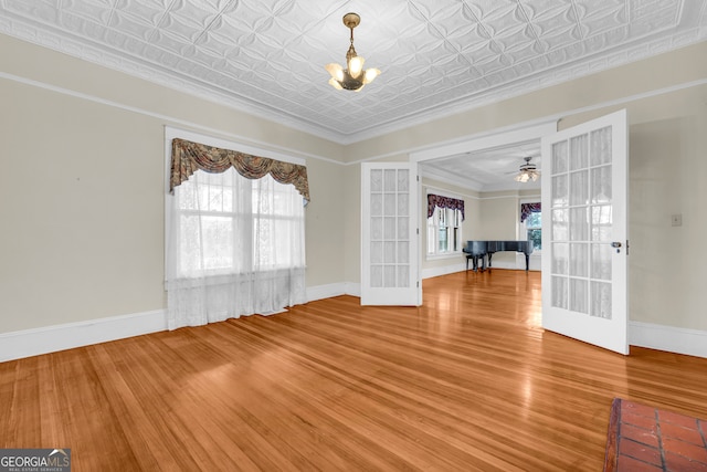 490 College St, Royston, GA 30662 - unfurnished room with a chandelier, wood finished floors, french doors, an ornate ceiling, and baseboards