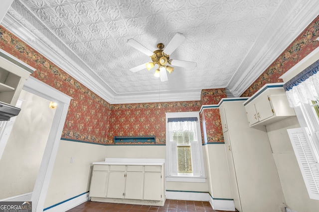kitchen with a ceiling fan, baseboards, ornamental molding, white cabinetry, and wallpapered walls