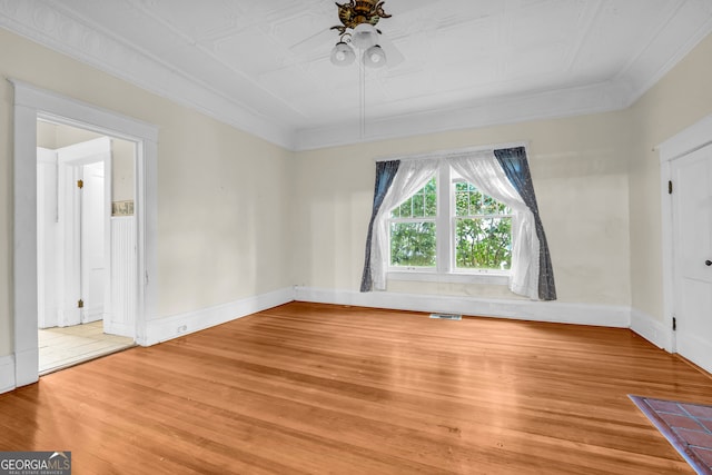 unfurnished room with light wood-style flooring, ornamental molding, ceiling fan, and baseboards