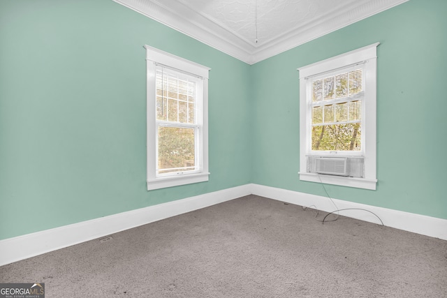 unfurnished room with cooling unit, healthy amount of natural light, carpet flooring, ornamental molding, and baseboards