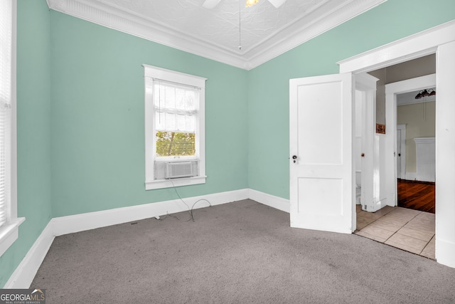 unfurnished room featuring carpet, ornamental molding, cooling unit, baseboards, and ceiling fan