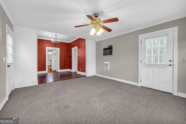 unfurnished living room featuring crown molding, a wall unit AC, ceiling fan with notable chandelier, and dark carpet