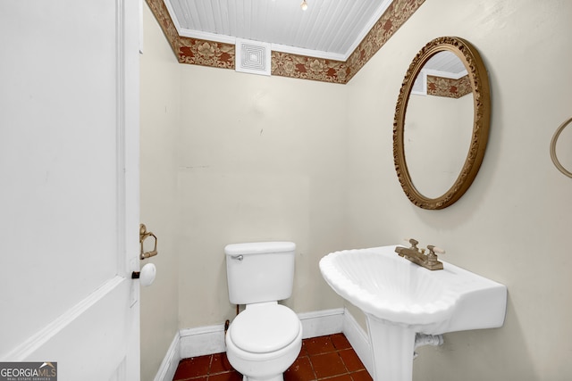 bathroom featuring tile patterned flooring, ornamental molding, and toilet