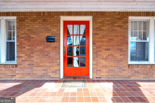 view of exterior entry featuring brick siding