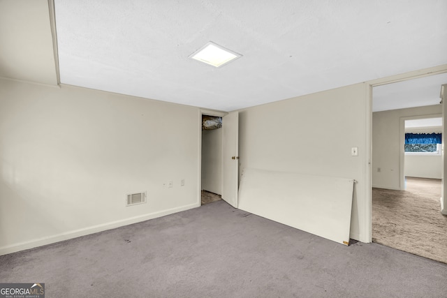 spare room featuring carpet flooring and baseboards