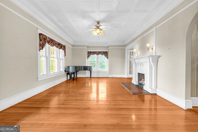 unfurnished living room with crown molding, hardwood / wood-style flooring, a fireplace, and ceiling fan with notable chandelier