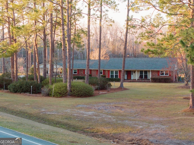 ranch-style home featuring a front lawn and brick siding