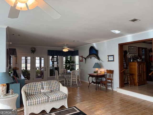 living area with light tile patterned floors, visible vents, a ceiling fan, ornamental molding, and a wealth of natural light