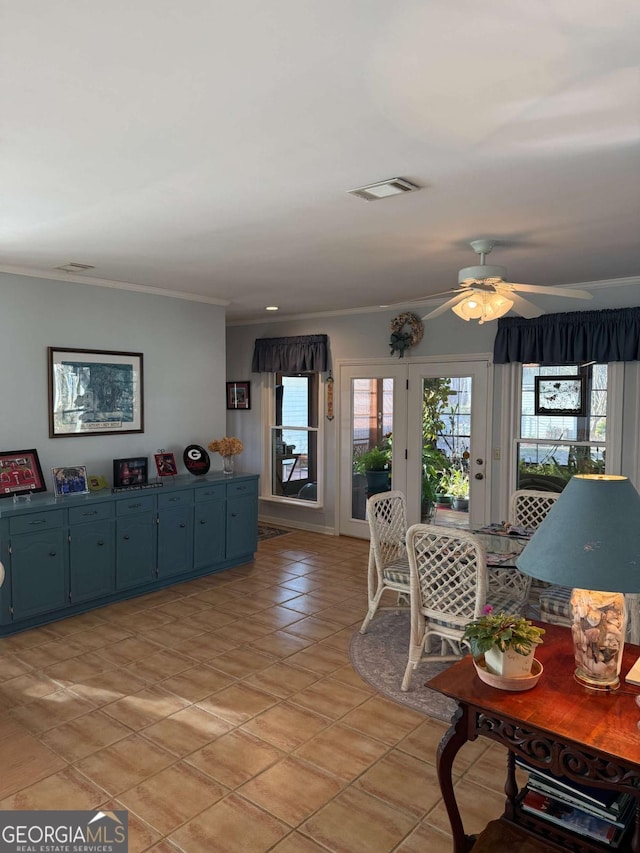 living room featuring a ceiling fan, light tile patterned floors, visible vents, and crown molding