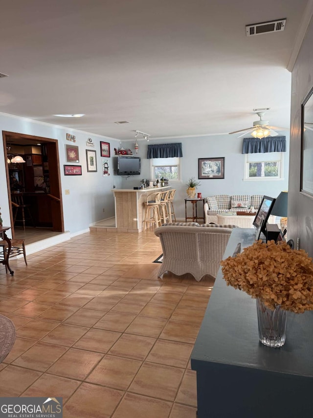 living area with light tile patterned floors, visible vents, and a ceiling fan