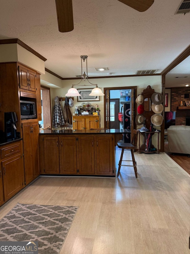 kitchen with dark countertops, stainless steel microwave, and visible vents