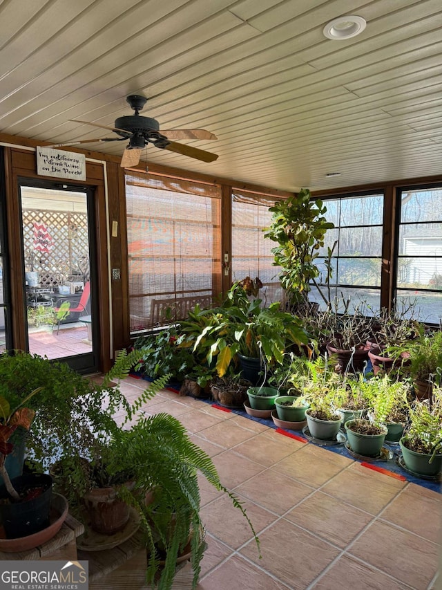 sunroom / solarium featuring wood ceiling and a ceiling fan