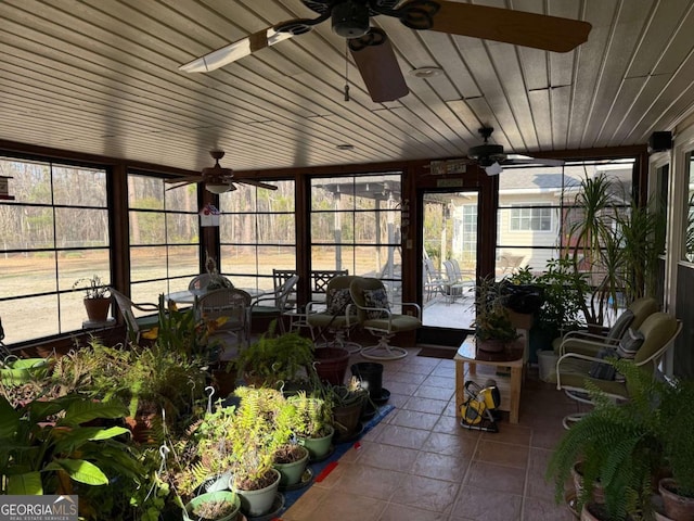 sunroom featuring wood ceiling, a ceiling fan, and a wealth of natural light