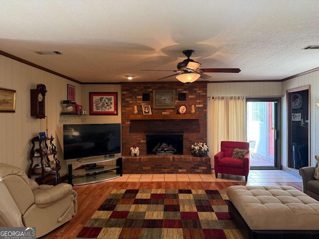 living area with ornamental molding, visible vents, and a textured ceiling