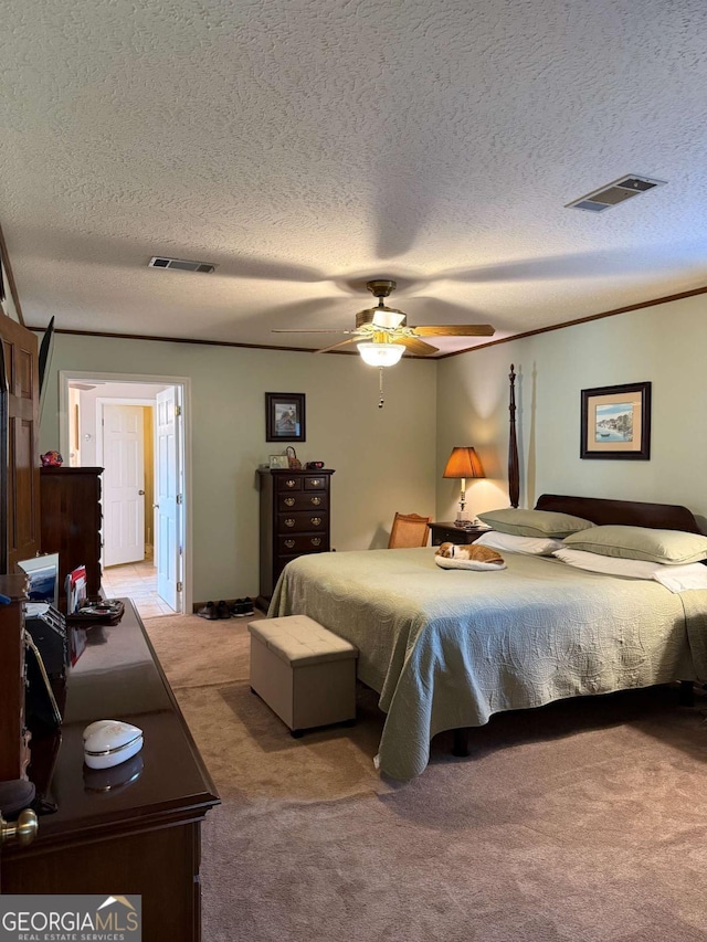 carpeted bedroom featuring a textured ceiling, visible vents, and a ceiling fan