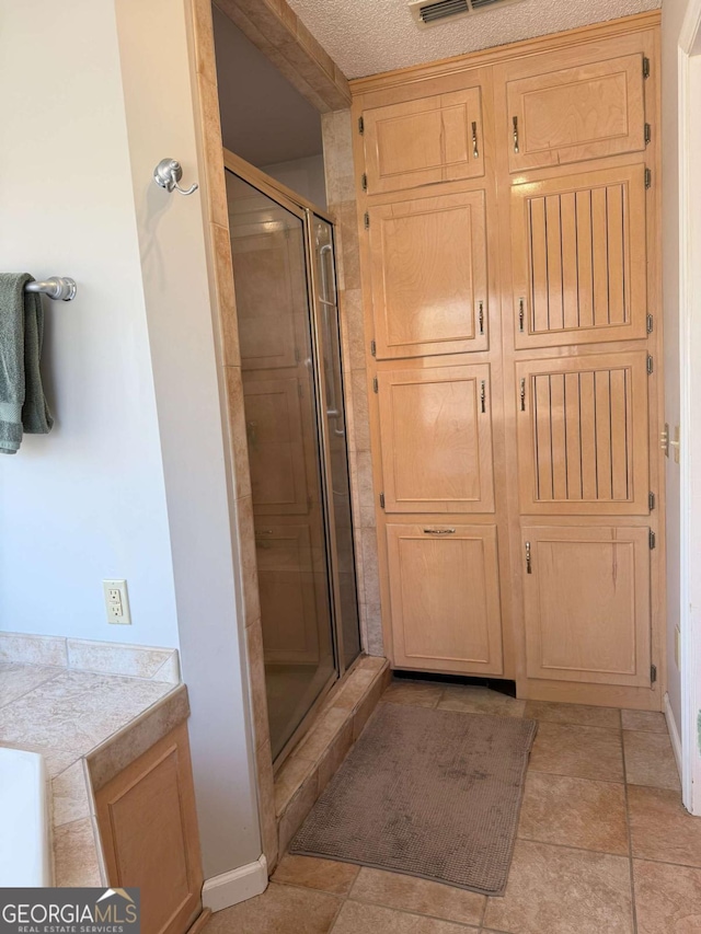 full bath with a stall shower and visible vents