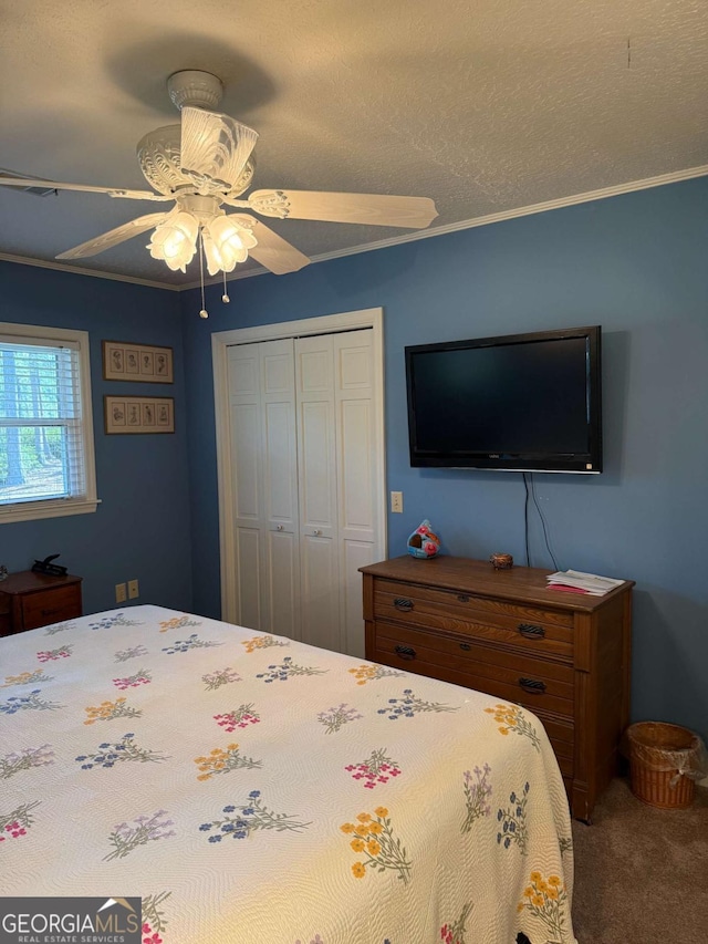 carpeted bedroom featuring a closet, ceiling fan, and a textured ceiling