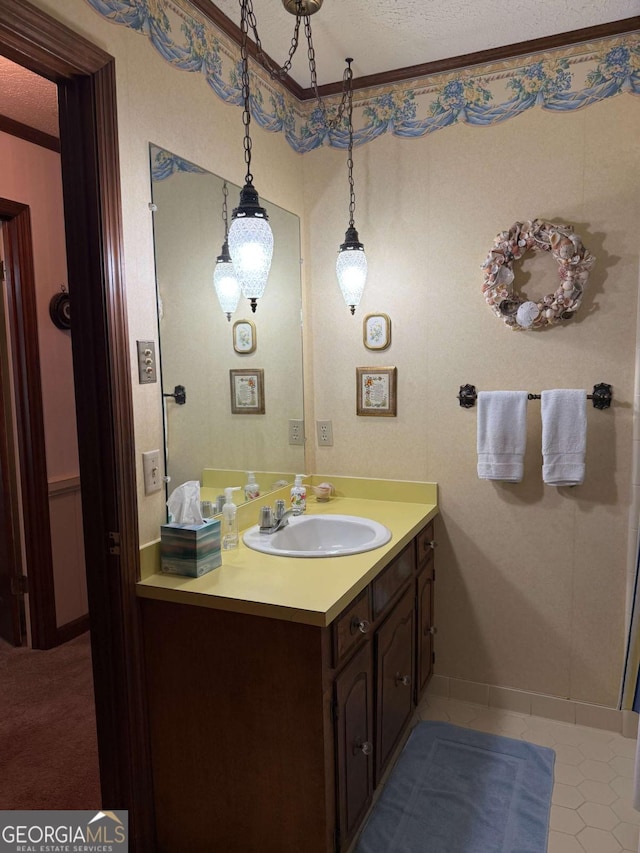 bathroom with ornamental molding, a textured ceiling, and vanity