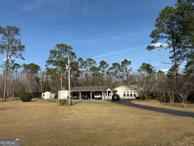 single story home featuring driveway, an attached carport, and a front yard