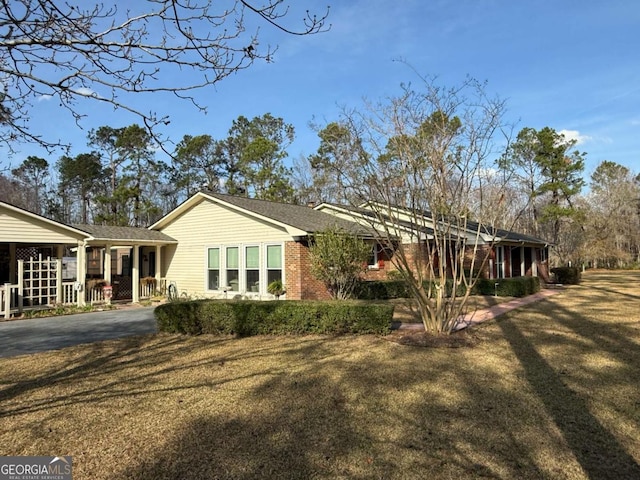 view of property exterior featuring brick siding and a lawn