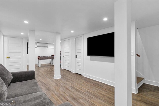 living room with hardwood / wood-style floors and an AC wall unit