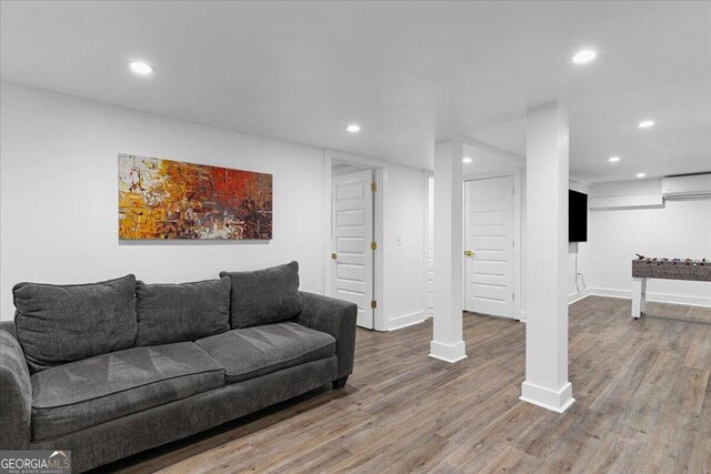 living room featuring hardwood / wood-style floors and a wall mounted air conditioner