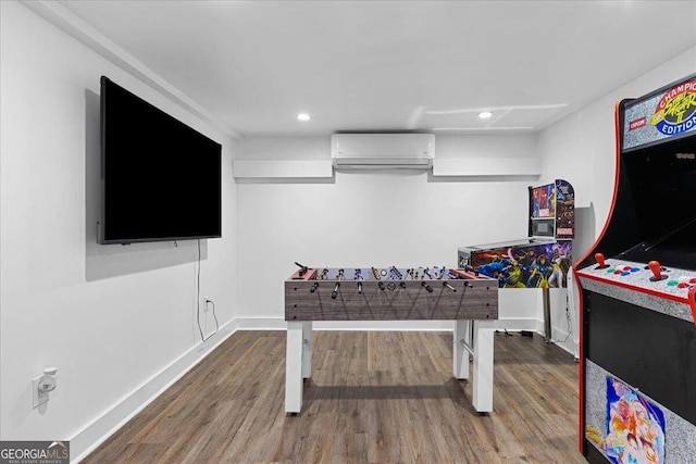 game room featuring hardwood / wood-style flooring and an AC wall unit