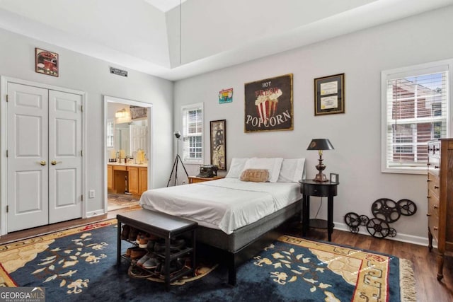 bedroom with dark wood-type flooring and ensuite bathroom