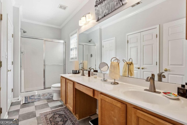 bathroom with crown molding, toilet, vanity, and a shower with shower door