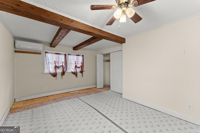 spare room featuring beamed ceiling and a wall mounted air conditioner