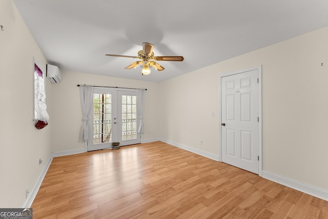 unfurnished room with french doors, ceiling fan, a wall unit AC, and light hardwood / wood-style flooring