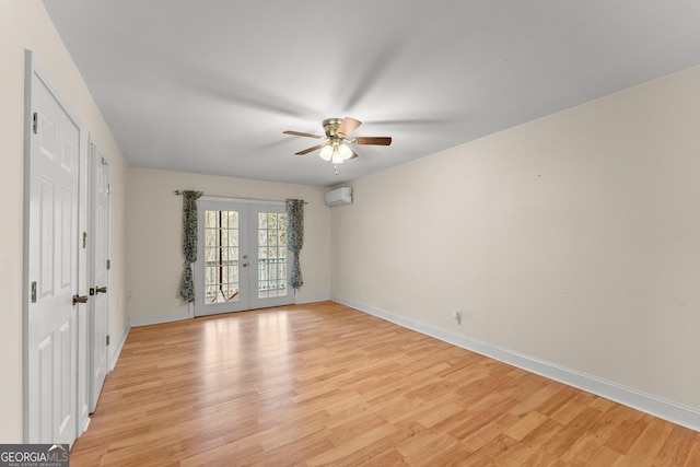 unfurnished bedroom with ceiling fan, a wall mounted air conditioner, access to outside, french doors, and light wood-type flooring