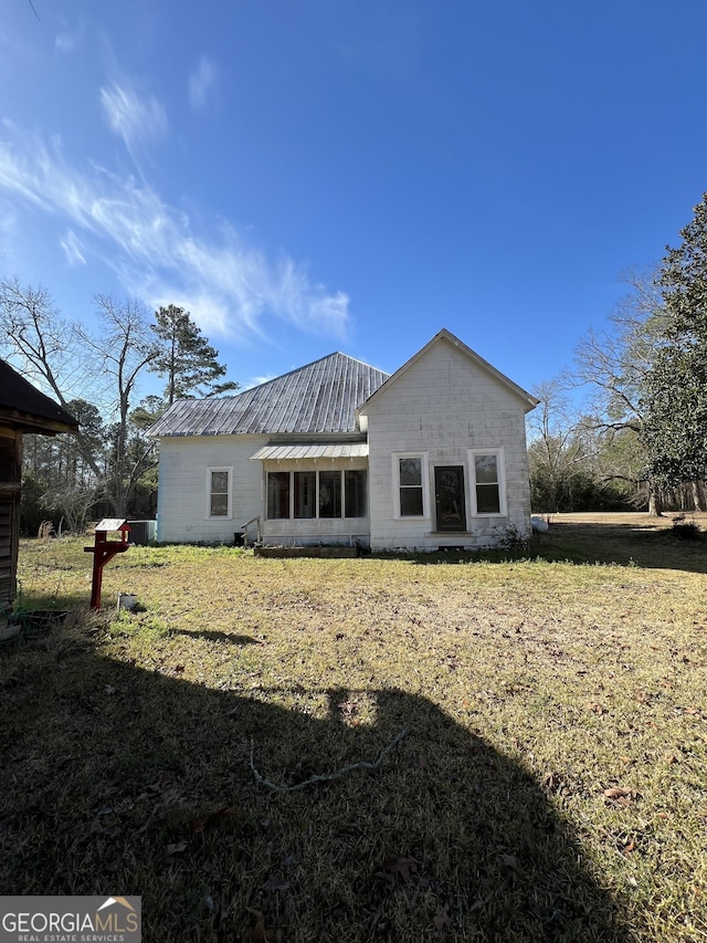 rear view of house featuring a lawn