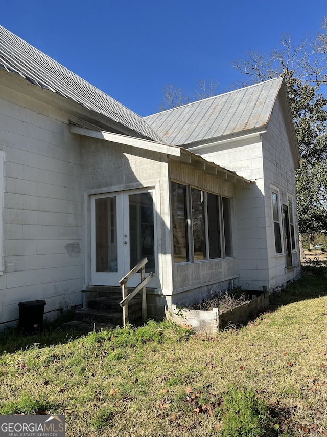 doorway to property featuring a lawn