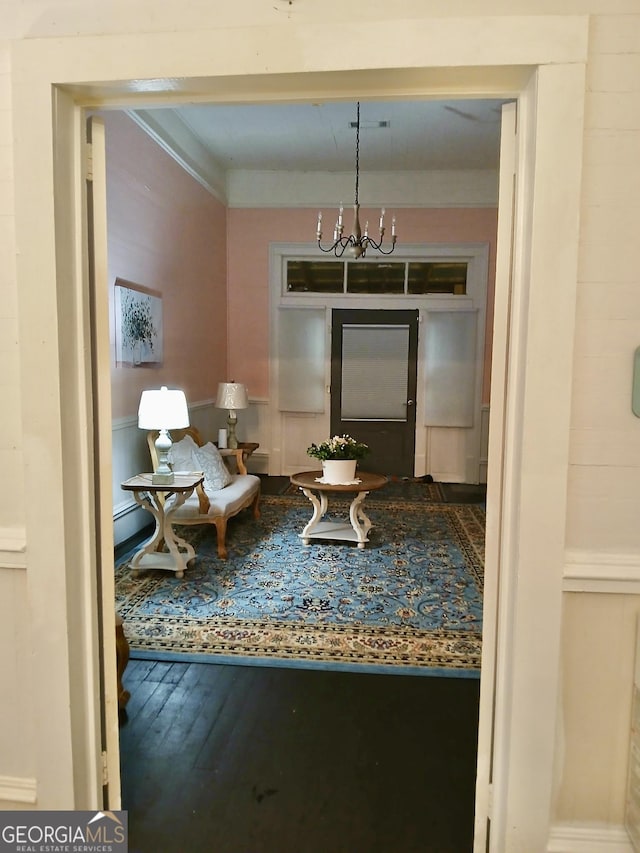 interior space with ornamental molding, hardwood / wood-style floors, and a chandelier